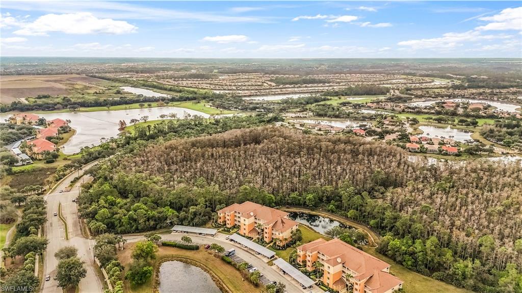 Aerial perspective showcasing multiple residential buildings with terracotta-style roofs, surrounded by extensive natural landscaping