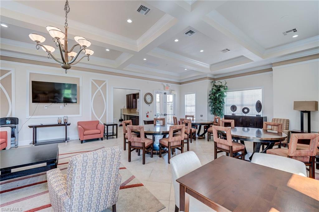 Dining space with hanging lights, ornamental molding, coffered ceiling, and light tile patterned flooring