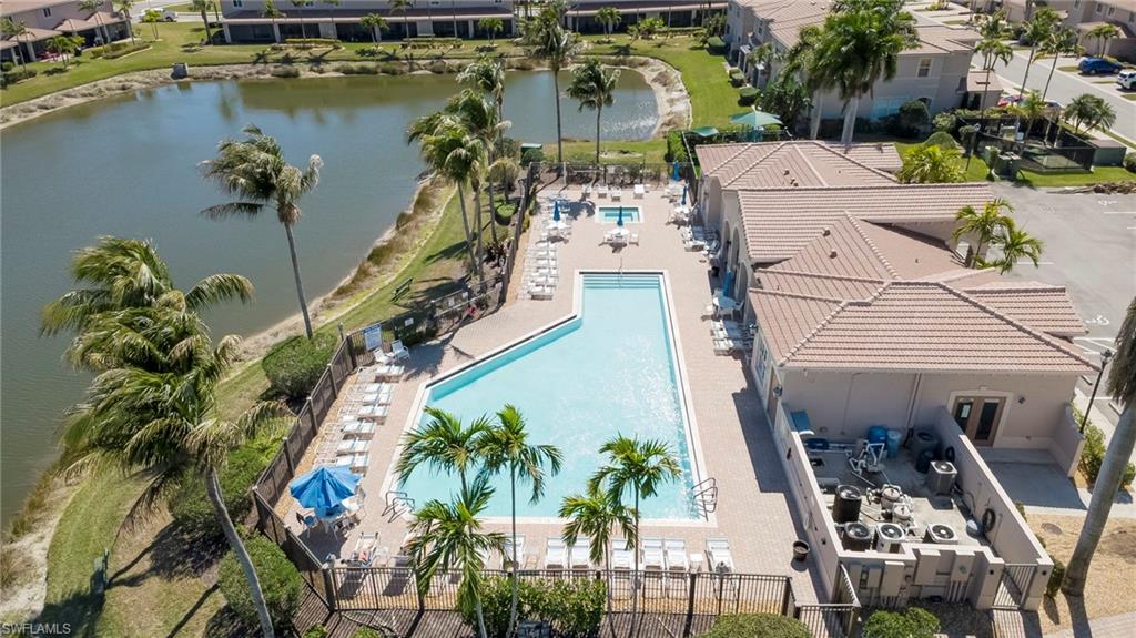 Aerial view of residential area with a large body of water and a pool