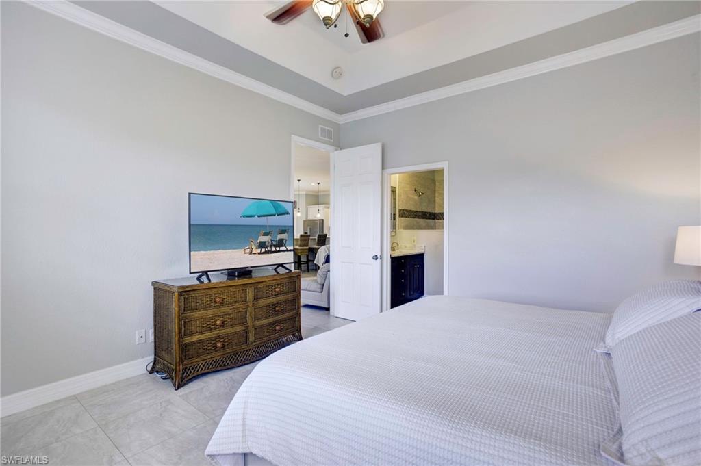 Bedroom featuring crown molding, ensuite bathroom, and ceiling fan