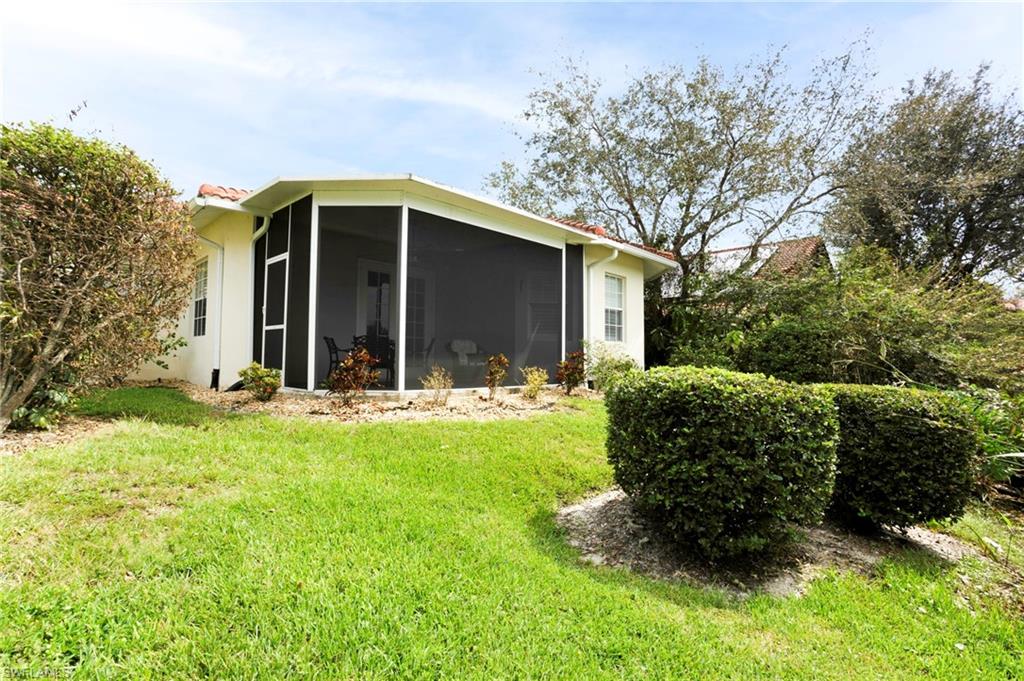 View of property exterior with a lawn and a sunroom