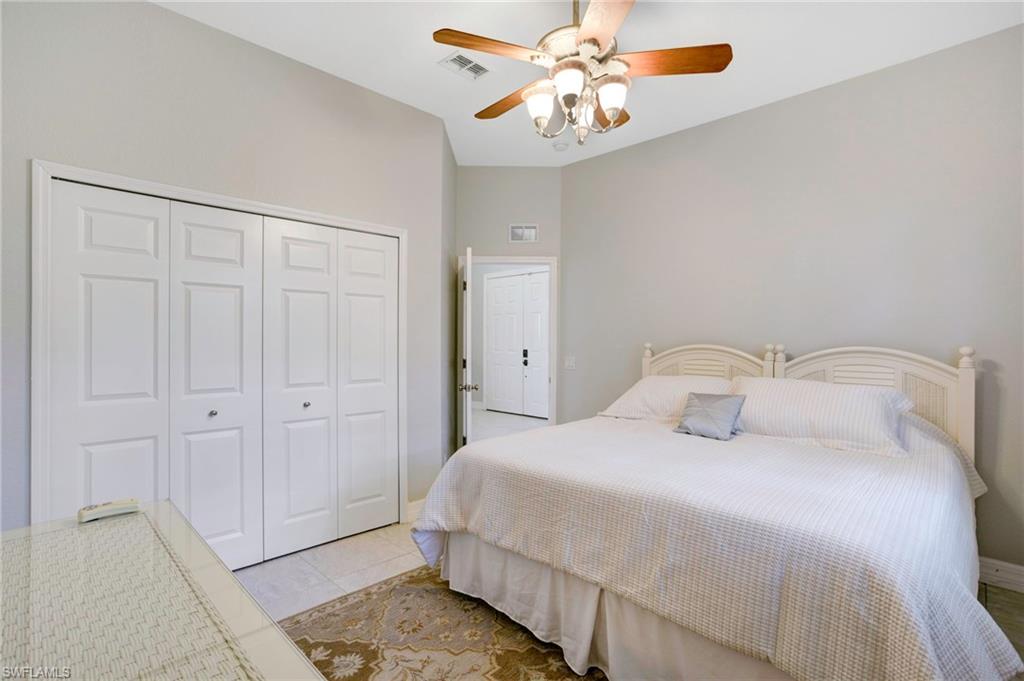 Tiled bedroom featuring a closet, vaulted ceiling, and ceiling fan