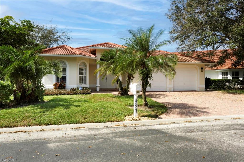 Mediterranean / spanish-style house with a garage and a front lawn