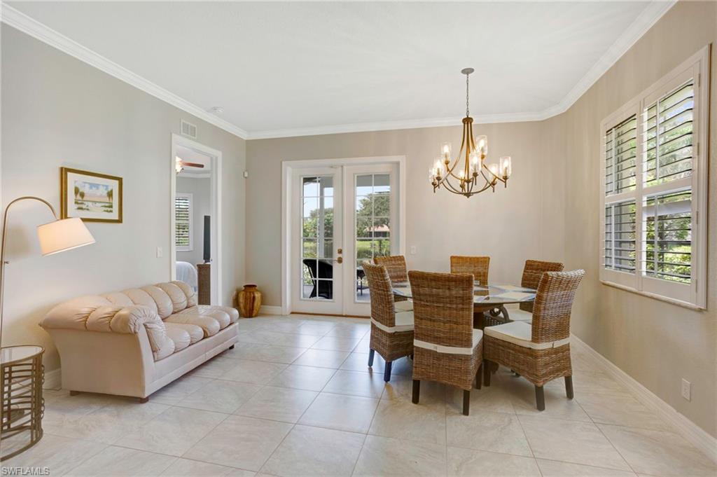 Dining space with french doors, crown molding, a chandelier, and light tile patterned floors