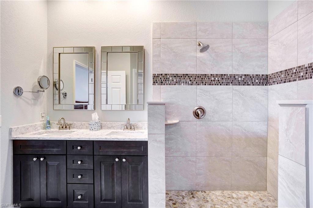 Bathroom featuring vanity and tiled shower