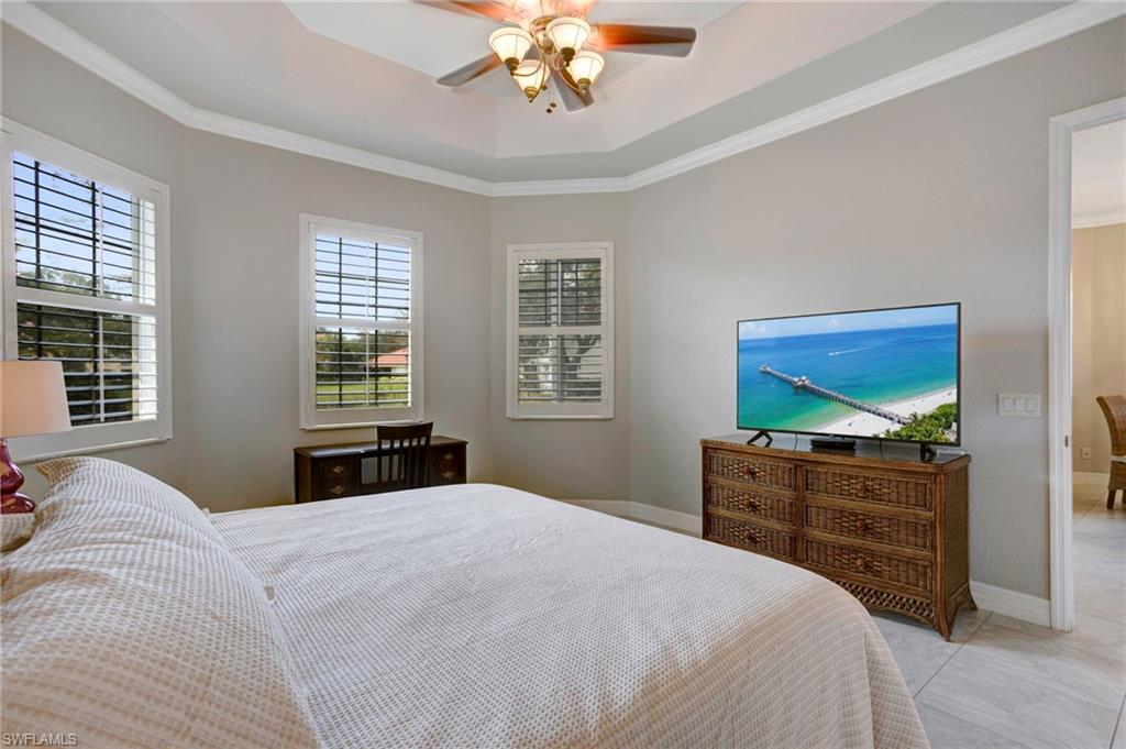 Tiled bedroom featuring crown molding, multiple windows, and ceiling fan