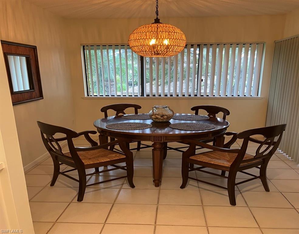 Tiled dining space featuring an inviting chandelier