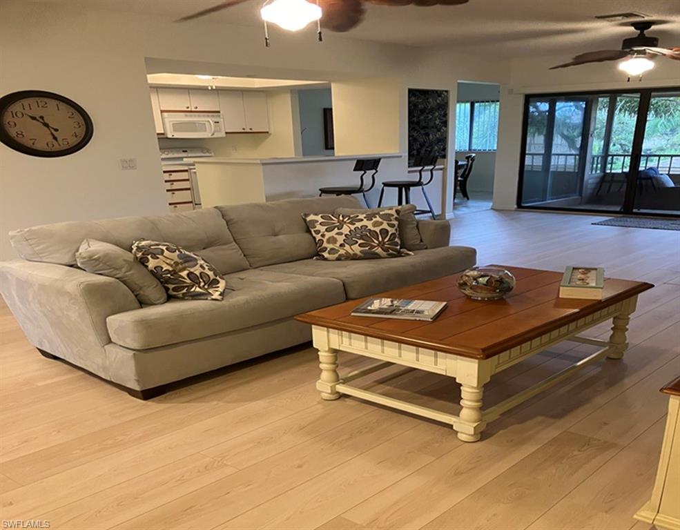 Living room with ceiling fan and light hardwood / wood-style flooring