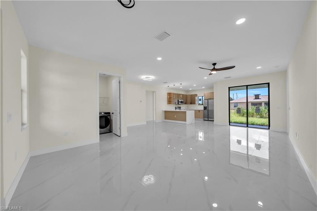 Open-concept living area featuring large format white tile flooring, recessed lighting, and a modern ceiling fan