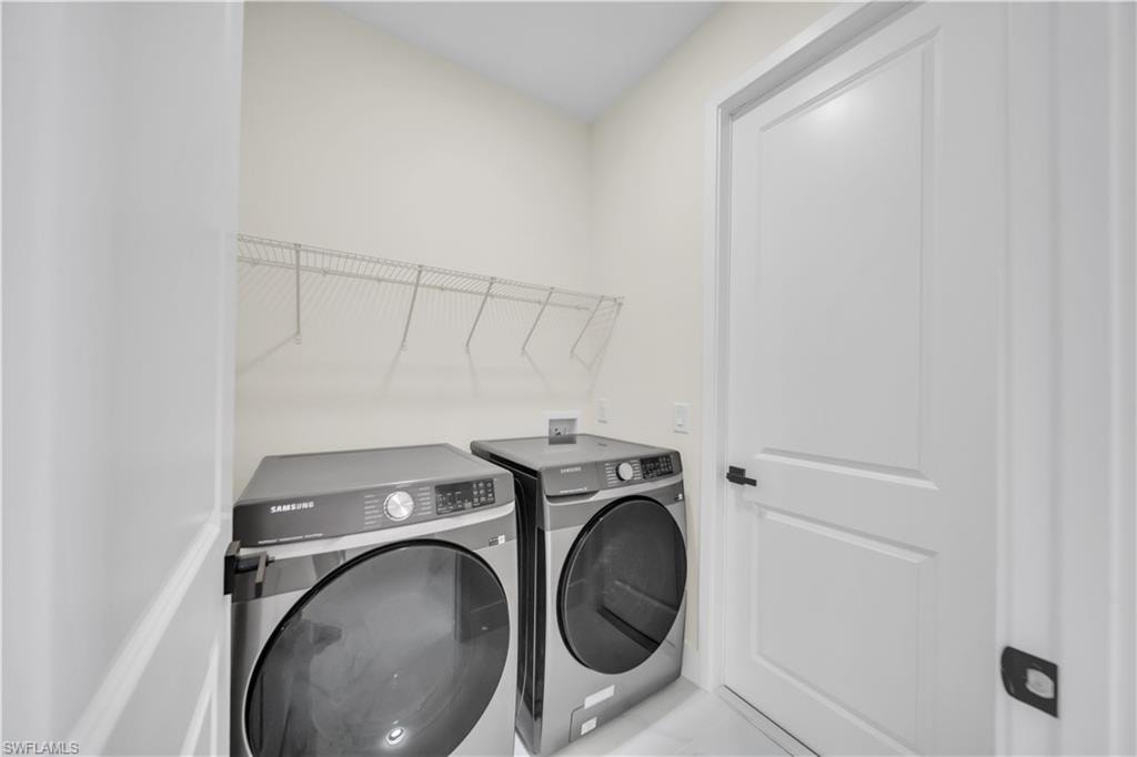 Dedicated laundry area featuring a wire storage shelf, light-toned walls, and a paneled white door with dark hardware