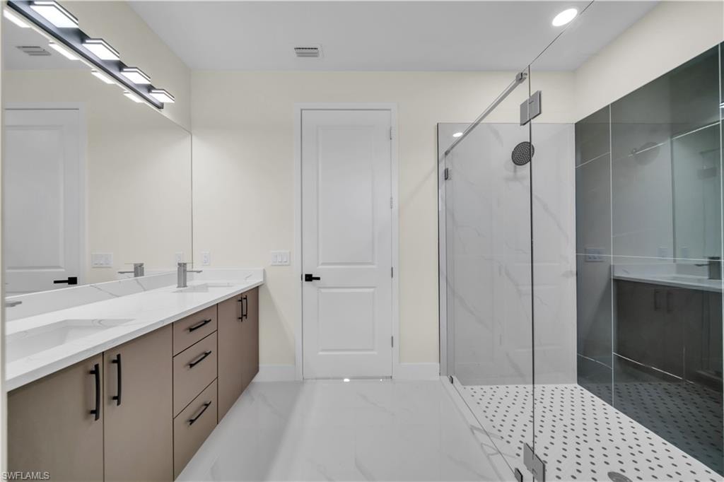 Contemporary bathroom featuring a frameless glass shower enclosure with white and gray tile accents
