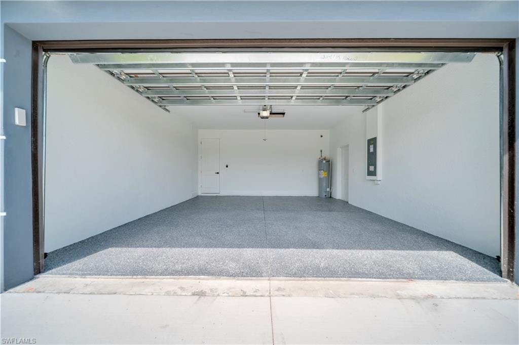 Spacious garage featuring a durable epoxy floor, white painted walls, and an accessible side entry door