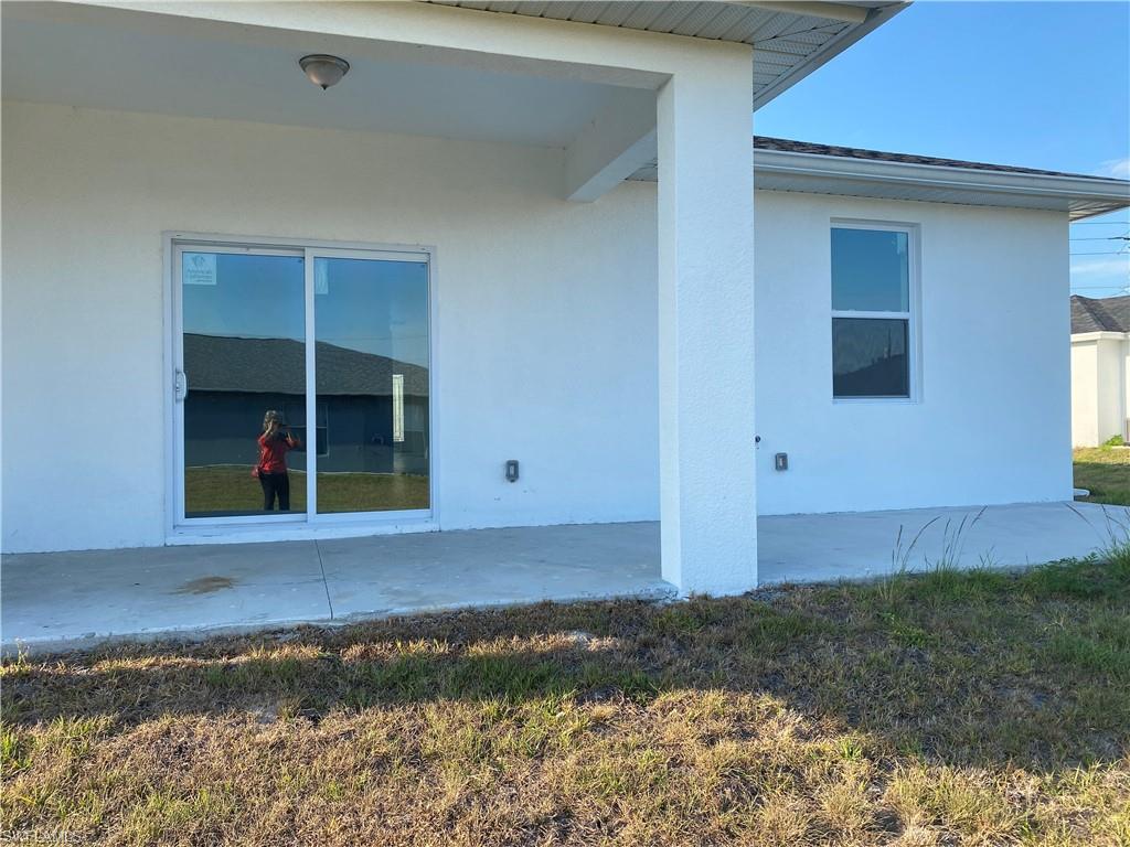 View of side of home featuring stucco siding and a patio area