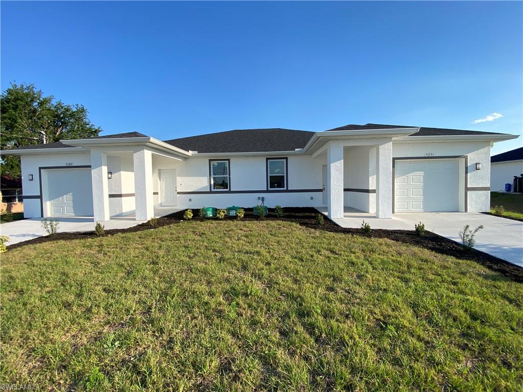 Ranch-style home with driveway, a front yard, stucco siding, and an attached garage