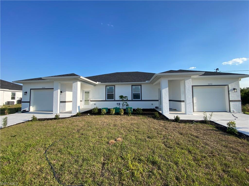 View of front of house featuring a garage, stucco siding, and driveway