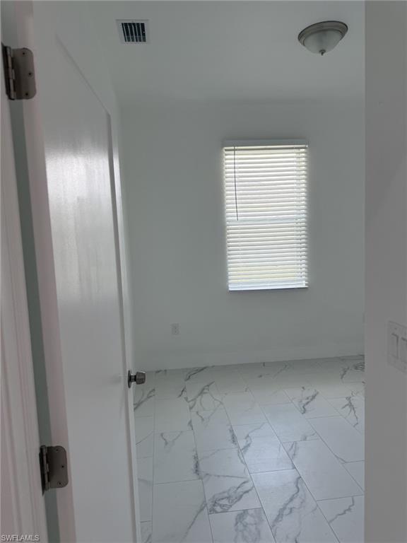 Empty room with marble finish floors and baseboards