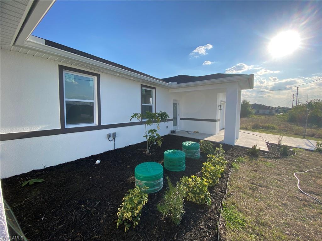 View of side of home featuring stucco siding and a patio area