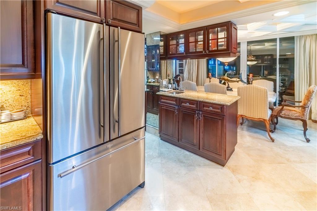 Stainless steel refrigerator integrated with dark wood-finish cabinetry