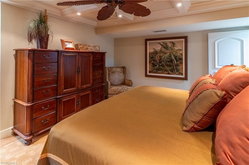 Recessed lighting illuminates a coffered ceiling with a ceiling fan