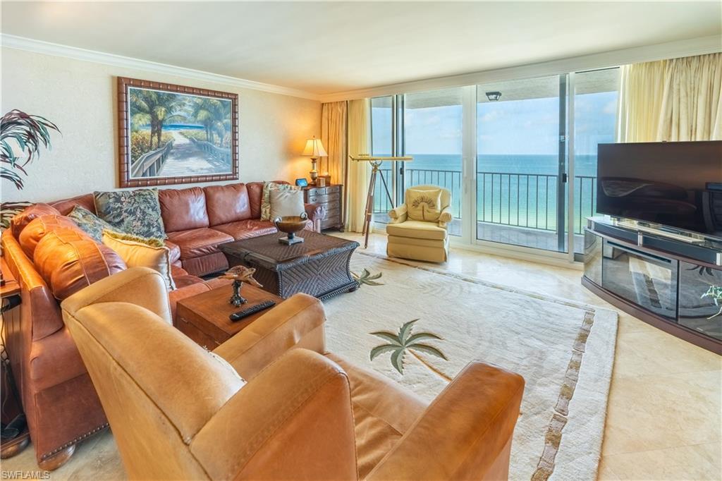 Expansive sliding glass doors open to a water backdrop