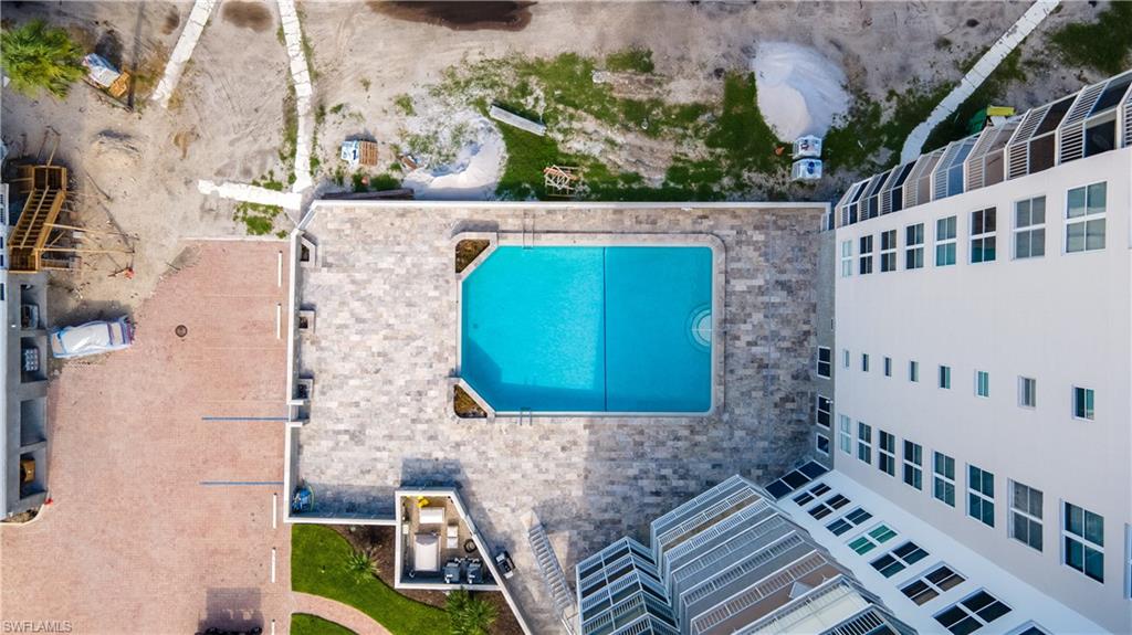 Outdoor swimming pool with integrated steps, surrounded by stone paver decking