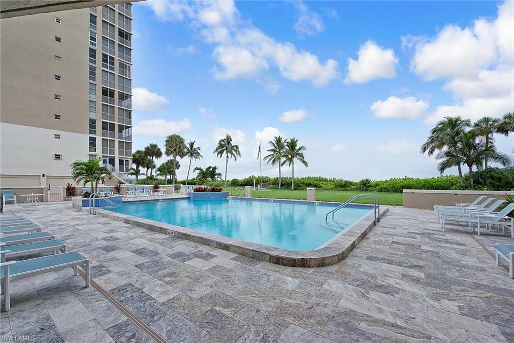 Resort-style swimming pool featuring a tiled surround and natural stone paver deck