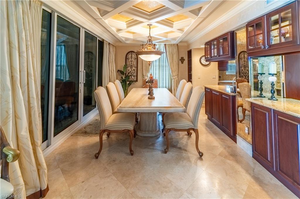 Formal dining area featuring a coffered ceiling with recessed lighting and a central chandelier