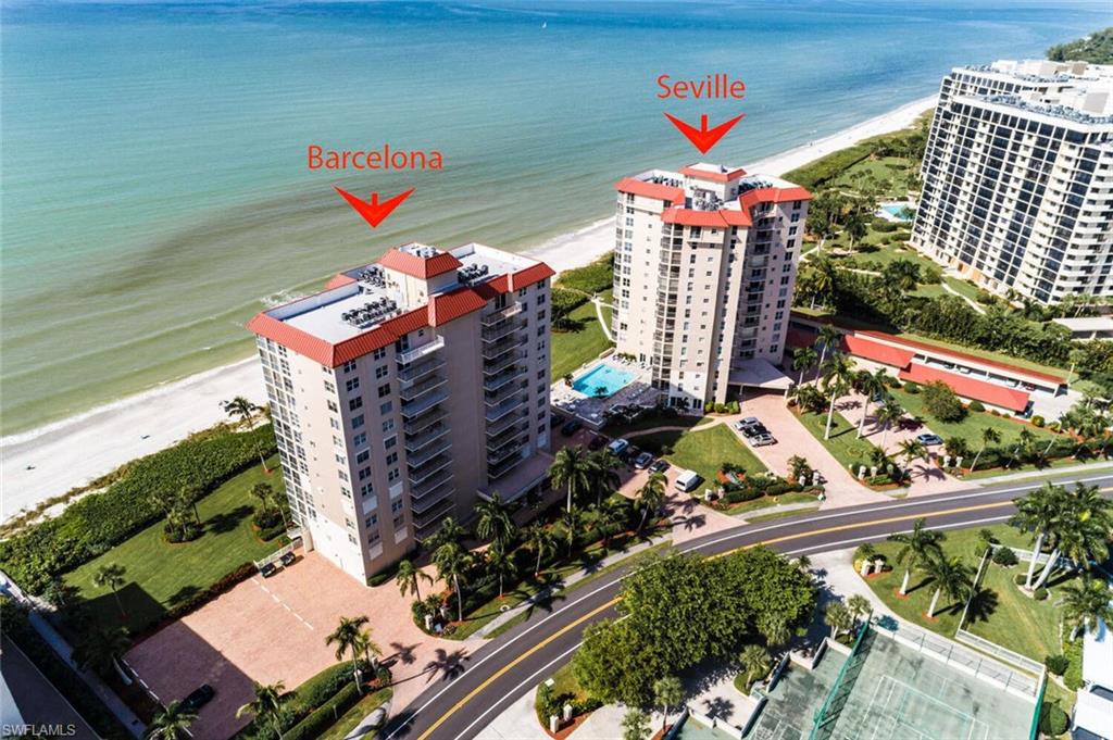 Aerial perspective showcasing two beachfront high-rise buildings with red tile roofs