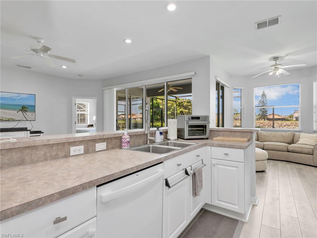 Kitchen featuring a double basin sink, white cabinetry, and light-toned countertops