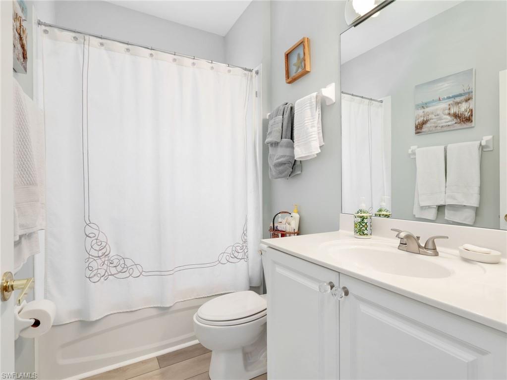 Bathroom featuring a white vanity with crystal knobs, an integrated sink, and a brushed nickel faucet