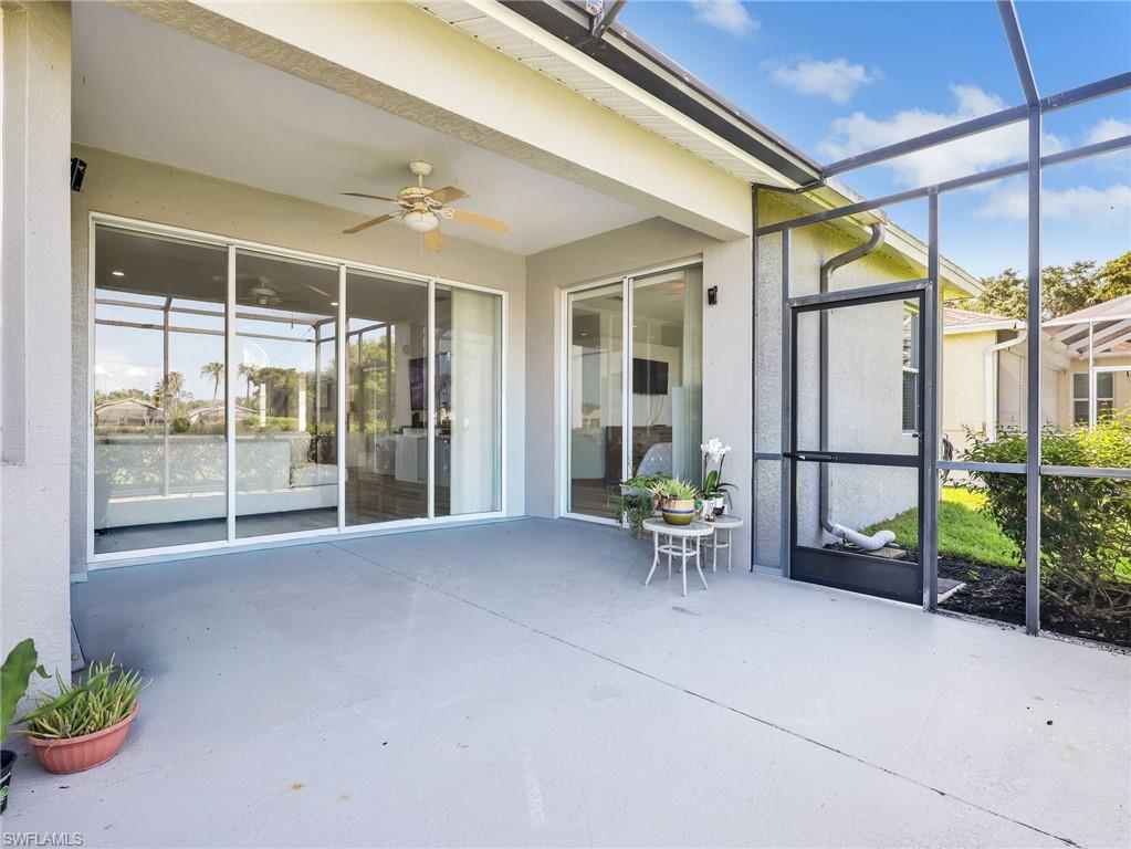 Expansive screened patio featuring a ceiling fan, direct access via sliding glass doors, and a neutral-toned concrete surface