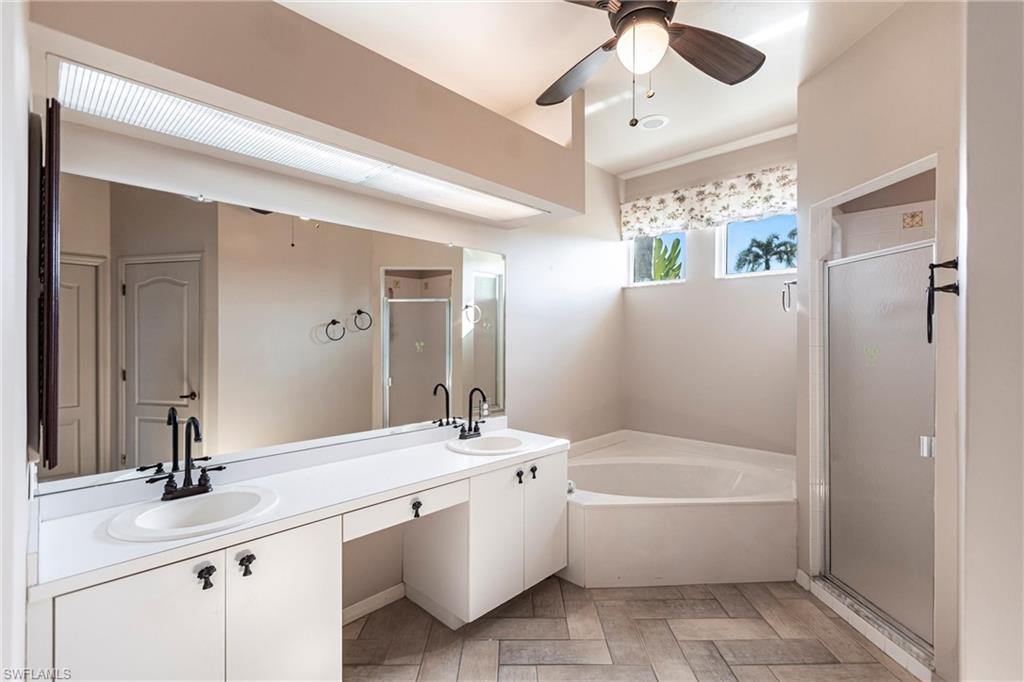 Bathroom featuring vanity, plus shower, soaking garden tub and ceiling fan and custom Imported Italian Tile, too!