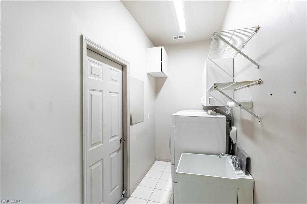 Washroom with technology (above) & storage cabinets, deep utility sink leading to garage.