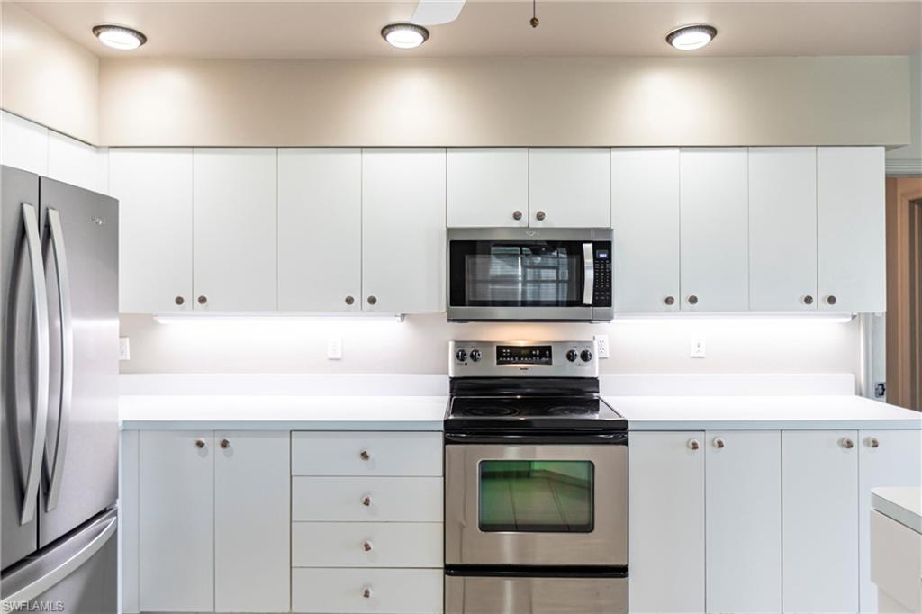 Kitchen featuring appliances with stainless steel finishes and white cabinets.