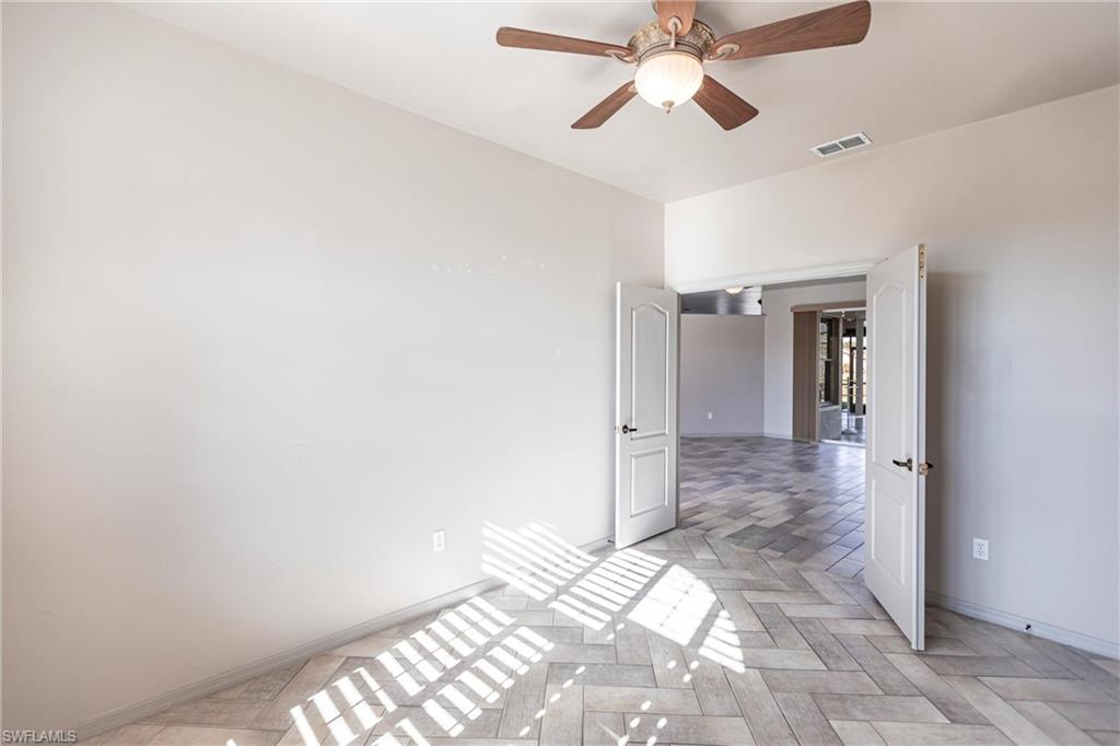 Looking out from den to living room and lanai with ceiling fan.