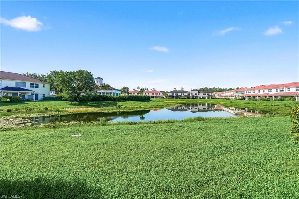 A scenic, central view of the community from your home, highlighting the lake, clubhouse, and lush landscaping.