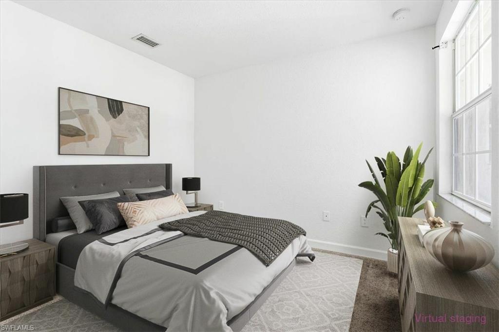 #2 Spacious bedroom with light-colored walls and a window offering natural illumination