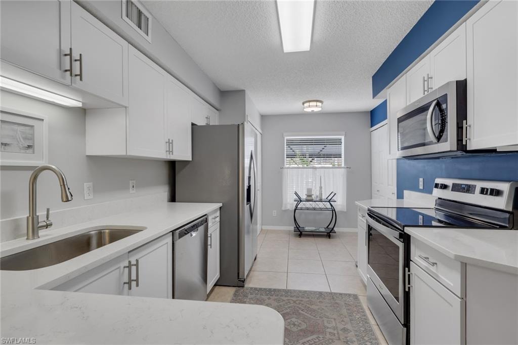 Remodeled with quartz countertops; pantry is just past the refrigerator and doors to the right are to the washer and dryer