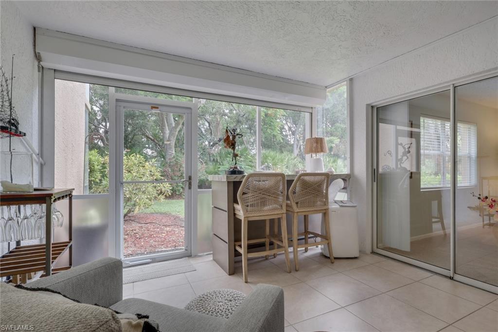 Enclosed sitting area with independent AC unit; slider doors lead to the primary bedroom; electric storm shutter
