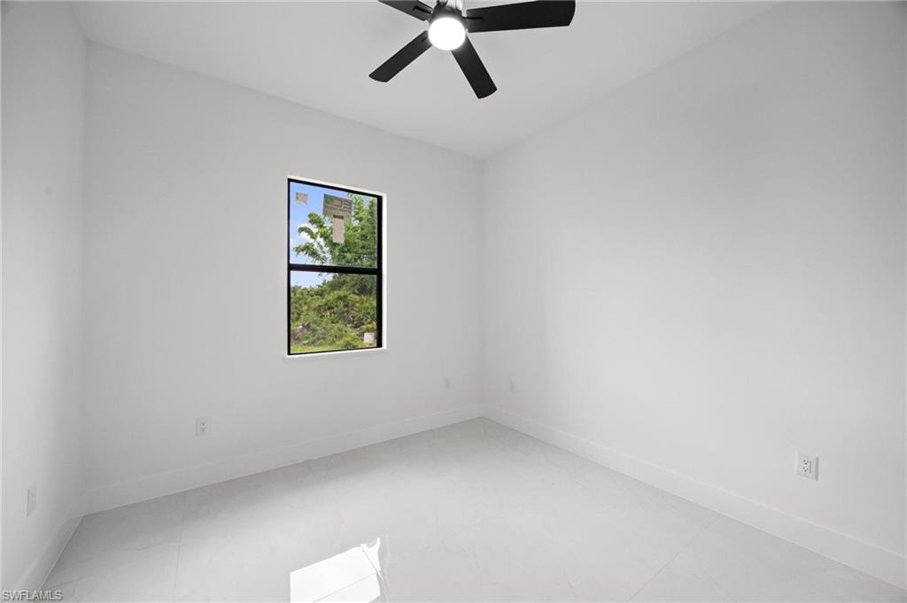 Bright room featuring a ceiling fan with light, white walls, and light-toned tile flooring