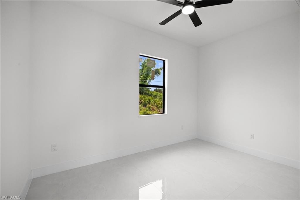 Bright room featuring a single window, white walls, and light-toned tile flooring