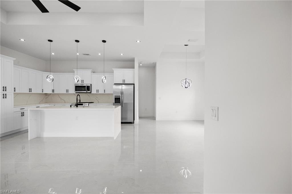 Modern kitchen featuring white cabinetry, a large center island, and stainless steel appliances