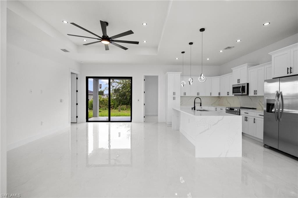 Open-concept living space with polished tile flooring, a modern ceiling fan, and recessed lighting