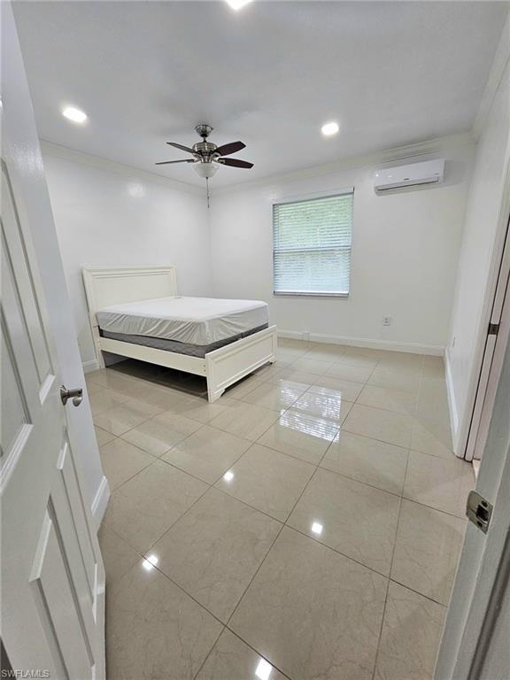 Spacious room featuring polished tile flooring, recessed ceiling lighting, a ceiling fan with integrated light, a window with blinds, and a wall-mounted air conditioning unit