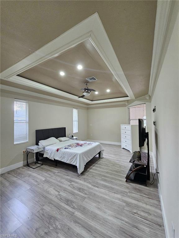 Master room featuring a tray ceiling with recessed lighting and a ceiling fan