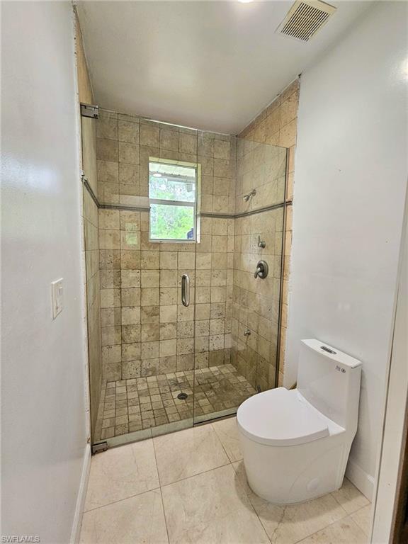 Glass-enclosed shower with tile surround and integrated window