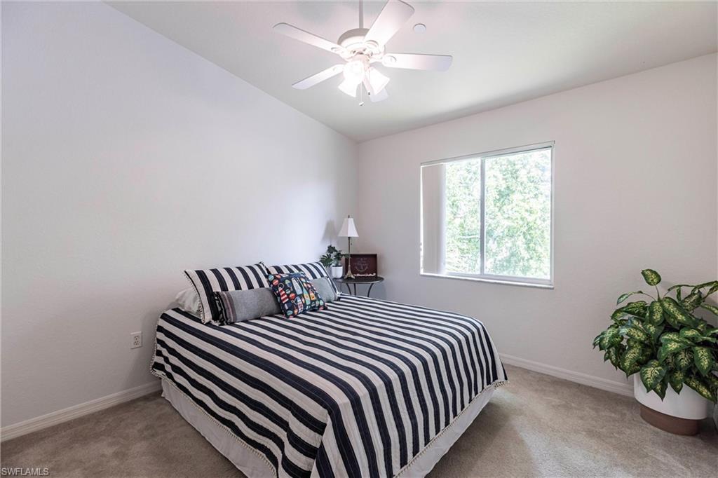 Carpeted bedroom featuring baseboards and a ceiling fan