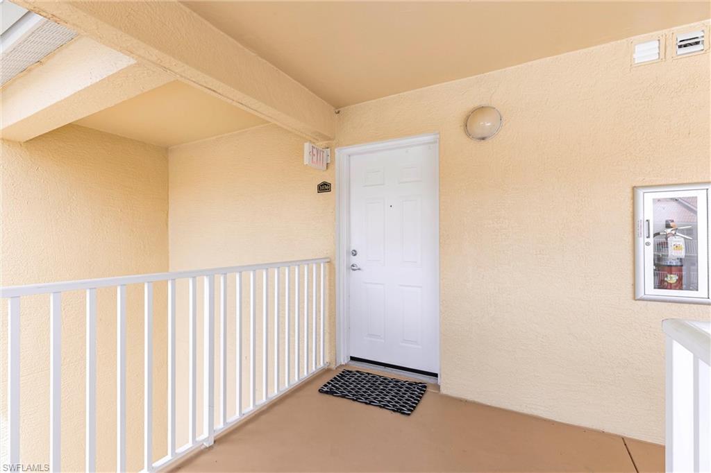Doorway to property featuring stucco siding