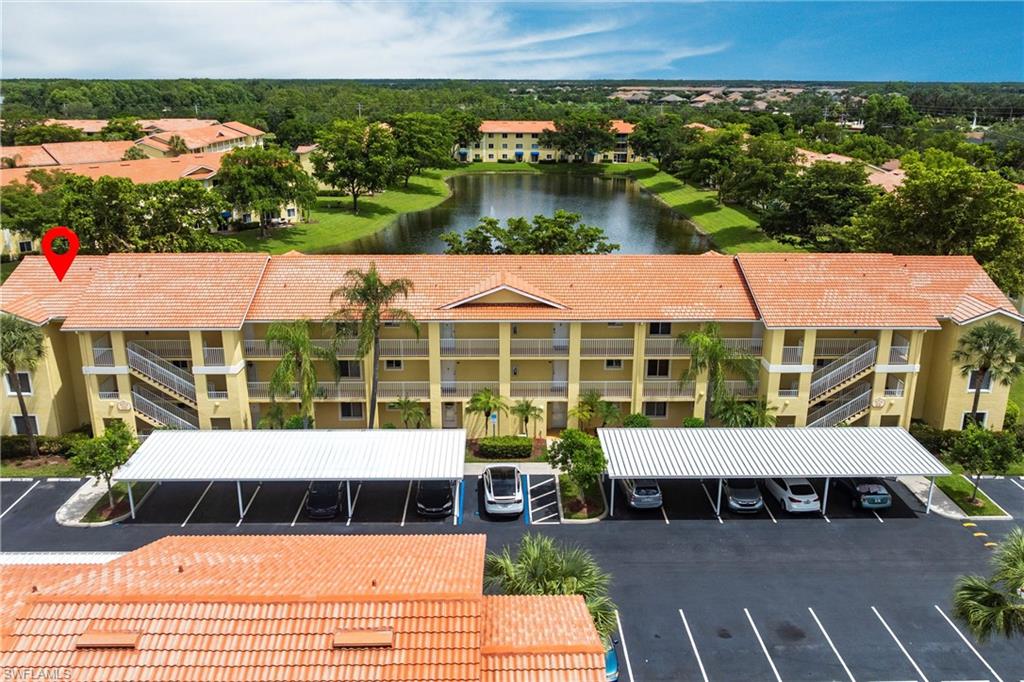 Drone / aerial view of a nearby body of water and apartment complex / building