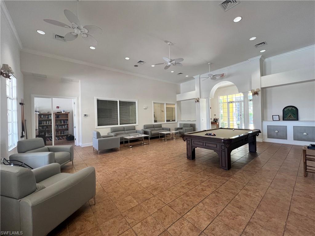 Rec room featuring crown molding, a towering ceiling, arched walkways, recessed lighting, and pool table